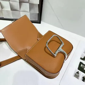 Bruine lederen schoudertas met zilveren hardware, stijlvolle crossbody tas voor dames.