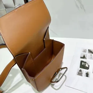 Gestructureerde bruine lederen schoudertas met witte stiksels en prachtige zilveren hardware.