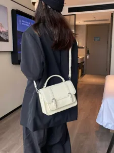 White leather messenger bag for women, stylish top-handle crossbody bag displayed on model.