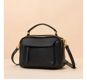 Black genuine leather boston bag detail, vintage shoulder handbag with gold hardware.