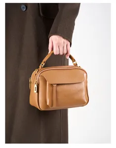 Close-up detail of the vintage brown leather handbag, showing exquisite stitching and texture.