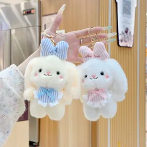 Detailed close-up shot of cute plush rabbit keychain featuring soft fur, plaid bow and metal ring.