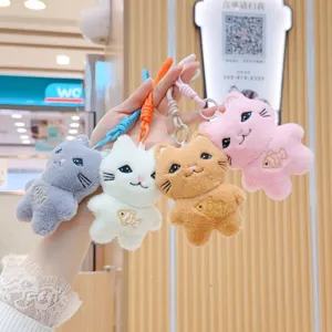 Closeup of cute cartoon cat plush pendants in multiple colors, featuring soft material and details.