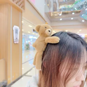 Detail view of cute brown plush teddy bear hair clip worn on hair, soft and stylish accessory.