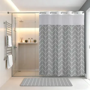 Grey chevron pattern shower curtain detail, modern hookless design with matching mat for bathroom.
