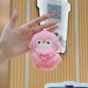 Primo piano dettagliato del simpatico portachiavi pinguino in peluche rosa con catena.