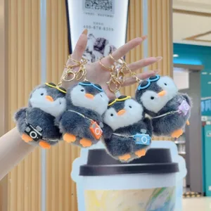 Cute plush penguin keychain with sunglasses and mini camera, fluffy doll toy pendant.