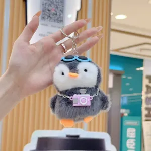 Adorable chubby penguin plush keychain toy featuring miniature camera and cool sunglasses close up