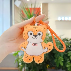 Detalle de llavero de peluche de tigre naranja, tela suave y bordado exquisito.