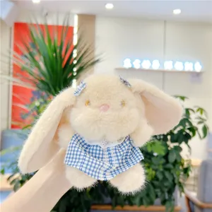 Close-up detail of cute plush bunny pendant with floppy ears and blue plaid dress, soft texture.