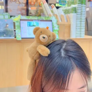 Close-up shot of the cute plush teddy bear hair clip worn on hair, showing soft texture detail.