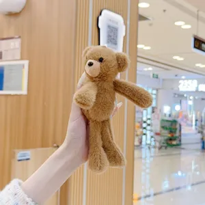 Close-up detail of a brown plush teddy bear hair clip, soft material and cute design.