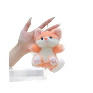 Cute plush orange fox keychain pendant, soft fluffy toy for car keys and bags. Handheld view.