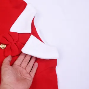 Children's Christmas costume detail close-up showing red fabric, white collar and bow.