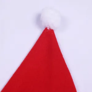 Red Christmas hat top detail closeup with soft white fluffy pom pom holiday festive decor