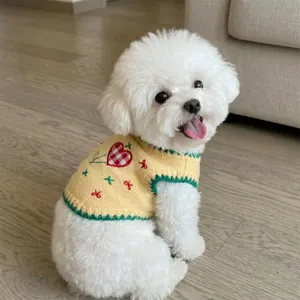 Vue détaillée du pull tricoté jaune pour animal de compagnie avec broderie cœur, vêtement chaud.