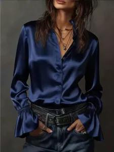Close-up of elegant dark blue satin blouse with ruffle sleeves