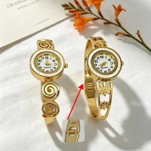 Nahaufnahme einer goldenen Armbanduhr aus Edelstahl mit hohlem Blumenmuster und S.-Stahl-Schnalle