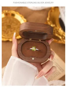 Close-up of an elegant S925 silver ring with a green peridot in a wooden box.