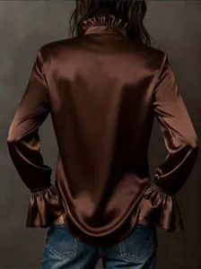 Back detail view of an elegant brown satin blouse with ruffled collar and flared cuffs