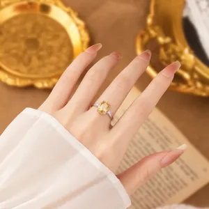 Elegant S925 sterling silver ring with an oval yellow crystal shown on a manicured hand.