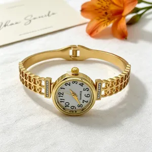 Nahaufnahme einer eleganten Damen-Goldarmbanduhr mit Hohlmuster und Strasssteinen