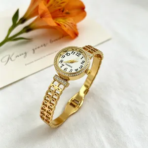 Detailansicht der eleganten goldenen Damenarmbanduhr mit Strass-Lünette und Hohlmuster