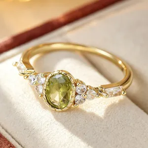 Close-up detail of a retro geometric olive zirconia ring with gold-toned finish and clear stones.