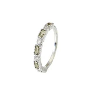 Close-up detail van vintage milgrain olijfgroene baguette en heldere diamant ring.