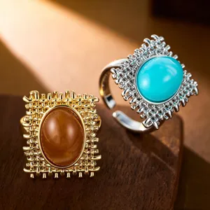 Detailaufnahme von Retro-Ringen mit Türkis und Bernsteinen auf einer Holzoberfläche.