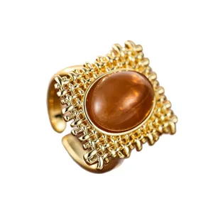 Retro vergoldeter offener Ring mit ovalem braunen Stein und vintage durchbrochenem Muster.