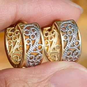 Detailed close-up of vintage gold silver two-tone filigree hollow wide hoop earrings design.