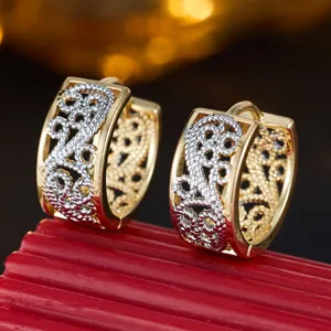 Close-up detail of two-tone gold and silver filigree huggie hoop earrings with retro court hollow.