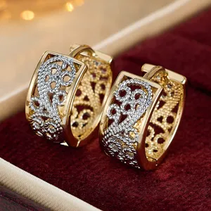 Detail shot of vintage two-tone gold silver filigree huggie earrings, court hollow wide stud design.
