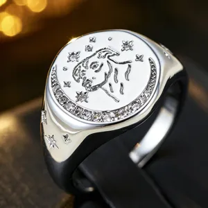 Nahaufnahme eines silbernen Siegelrings mit Sternbild-Gravur und funkelnden Zirkoniasteinen.