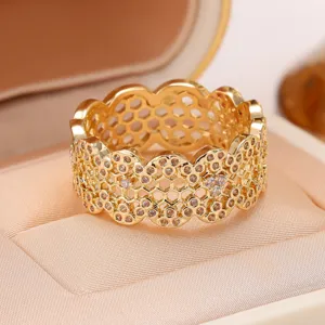 Close-up detail of a vintage gold wave honeycomb hollow ring, sparkling micro-paved cubic zirconia.