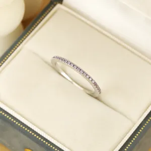 Nahaufnahme eines zarten silbernen Pave-Rings mit funkelnden rosa Steinen in Schachtel.