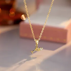 Closeup detail of dainty gold cocktail glass pendant necklace with sparkling zircon stone elegance.
