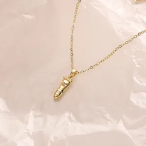 Detail shot of a creative bullet-shaped pendant necklace, trendy gold clavicle chain design.