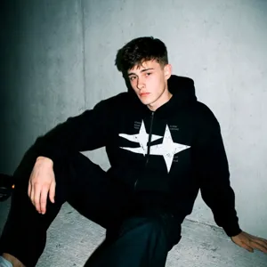Vue détaillée d'un sweat à capuche zippé noir avec un imprimé étoile blanc et un style streetwear.