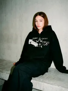 Vue détaillée du sweat à capuche noir avec graphique de voiture rétro et texte imprimé.