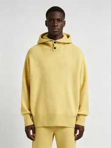 Détail d'un pull à capuche jaune pour homme avec col haut boutonné et maille côtelée.