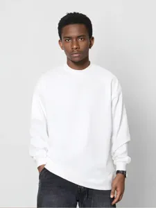 Detail van zwaar effen shirt met lange mouwen, losse oversize pasvorm en ronde halslijn.