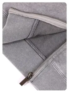 Detailed view of grey washed heavy zip hoodie showing metal zipper and loop fabric texture.
