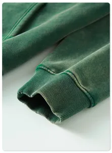 Close-up detail shot of men's vintage washed green heavyweight hoodie cuff and sleeve.