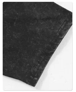 Close-up detail of vintage acid wash black t-shirt sleeve showcasing distressed texture.