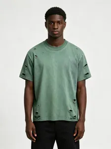Dettaglio della maglietta da uomo oversize verde slavata e pesante con strappi.