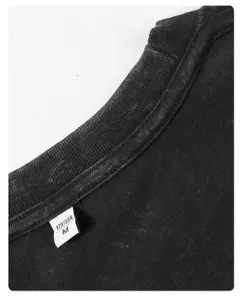 Close-up detail shot of black vintage washed short sleeve t-shirt collar with size label M.