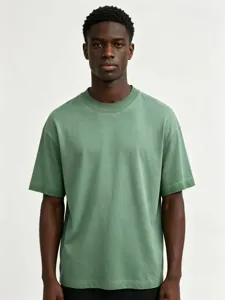 Closeup view of a men oversized distressed washed green short sleeve t shirt with vintage details.