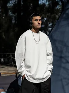Vista dettagliata di un modello asiatico con t-shirt a maniche lunghe oversize e tinta unita.